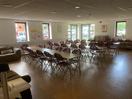 A photograph of a room at the Oasis Hub Hull set up with tables and chairs in rows