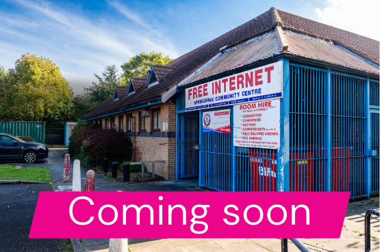A photograph taken from outside of Spring Bank community centre with text saying coming soon