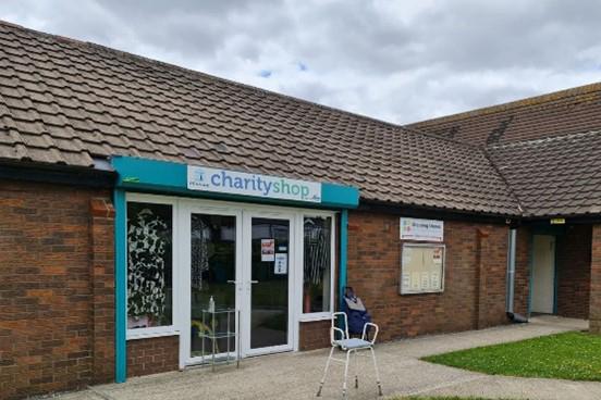 A photograph taken outside of The Pennine community centre focusing on the charity shop