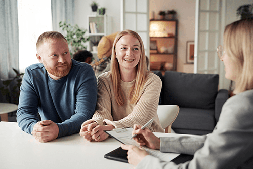 2 Smiling adults having a meeting with a woman