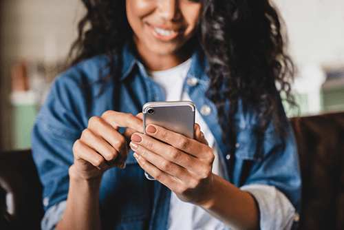 A photograph of a woman holding a mobile phone